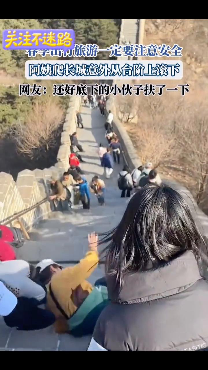 春季出行旅游一定要注意安全。阿姨爬长城意外从台阶上滚下。网友：还好底下的小伙子扶