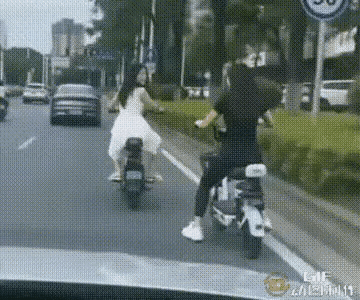 常能看到在公路或街道上，一前一后骑着电动车或摩托车的骑手。一人骑车在前，另一人在