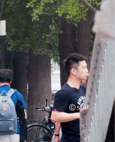 一边手拿着饮料，一边手拿着果冻