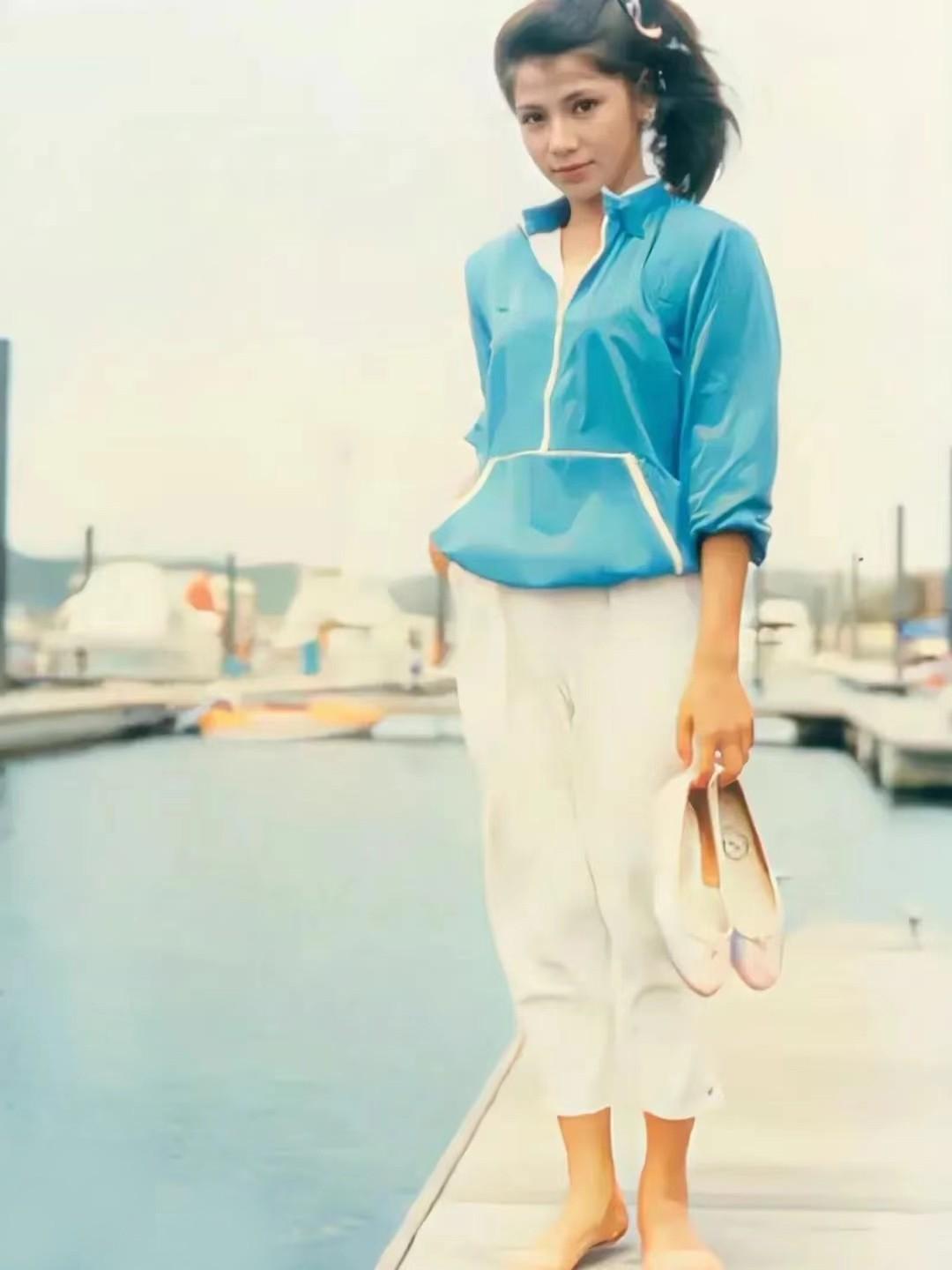 80年代初期，翁美玲站在海边的小船上，拍下了这张带着“蓉儿”式微笑的照片。

镜