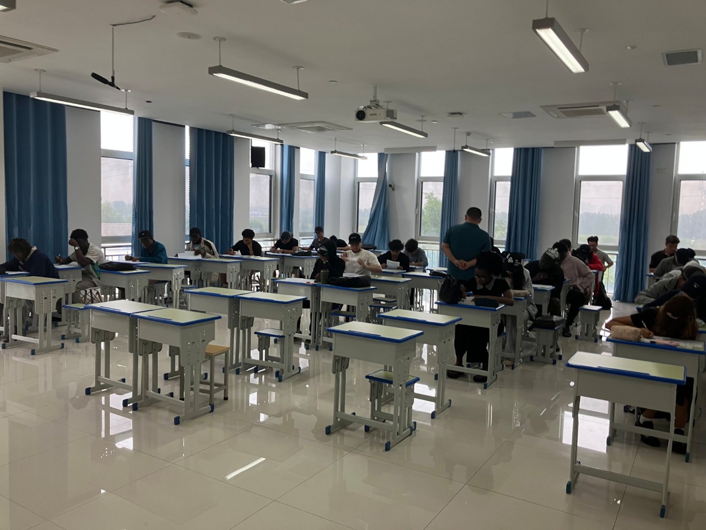 这是今天监考时候巡考的同事拍的，从后面看我已经是个资深教师的样子了