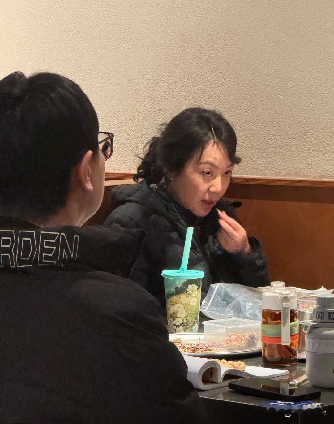 54岁闫妮和好友任素汐在沈阳一家餐馆吃烤肉，她穿着羽绒服，烫了一头卷发，看起来挺