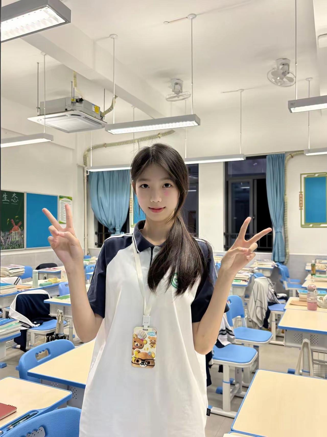 在教室里，女生比出胜利手势。