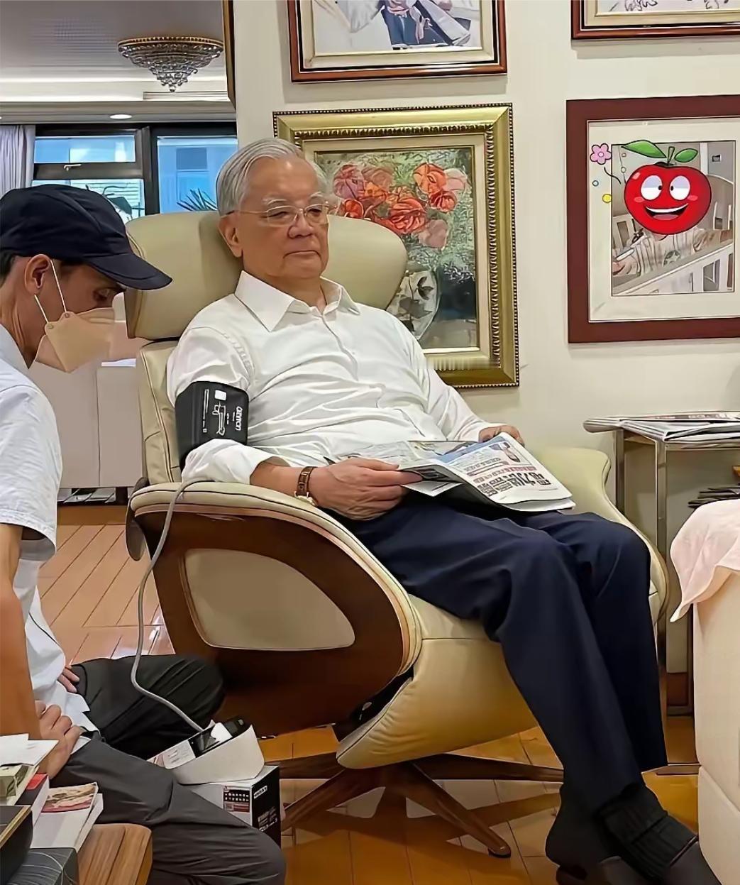 大家知道这位白发苍苍老人坐在沙发上，拿着报纸，气定神闲，等待工作人员给他量血压的