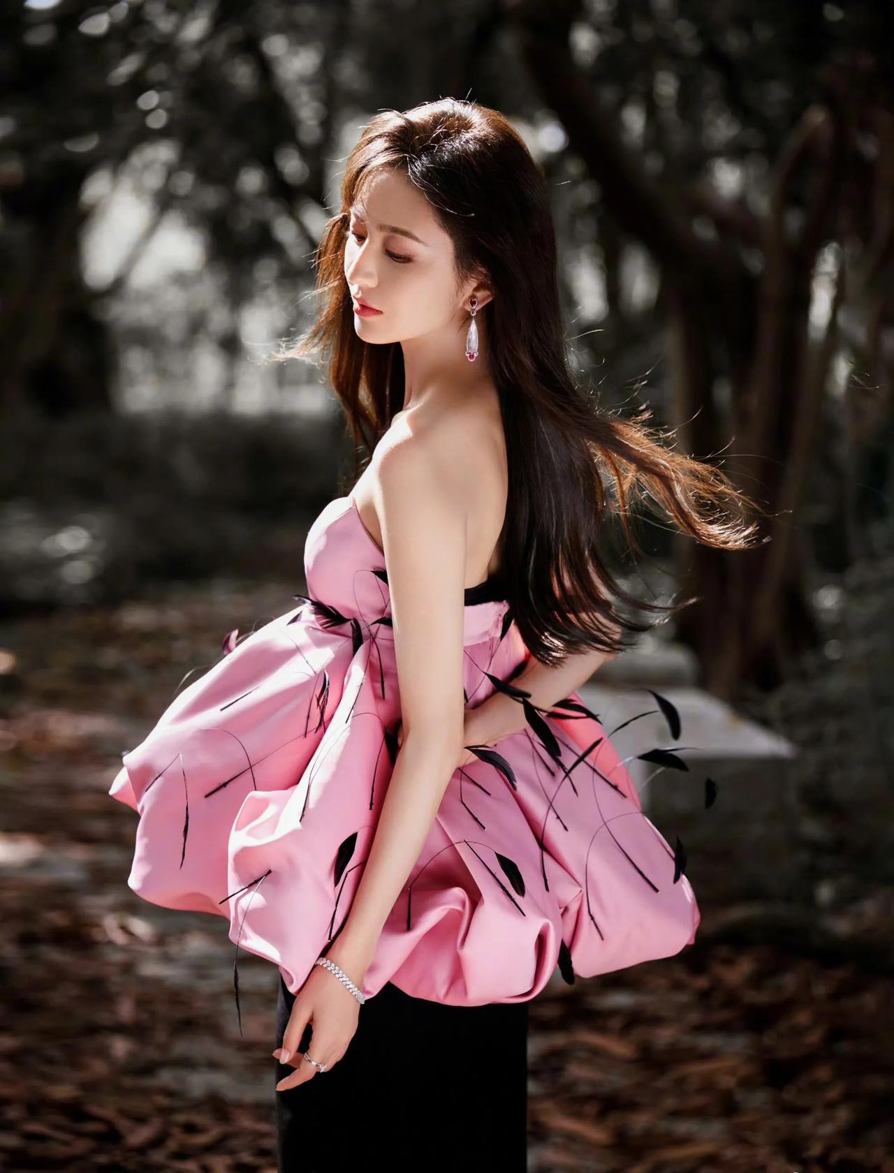 微风轻柔的吹起她的秀发，阳光下的她，一身粉色可爱的喇叭形状的衣服！柔美秀丽的侧颜