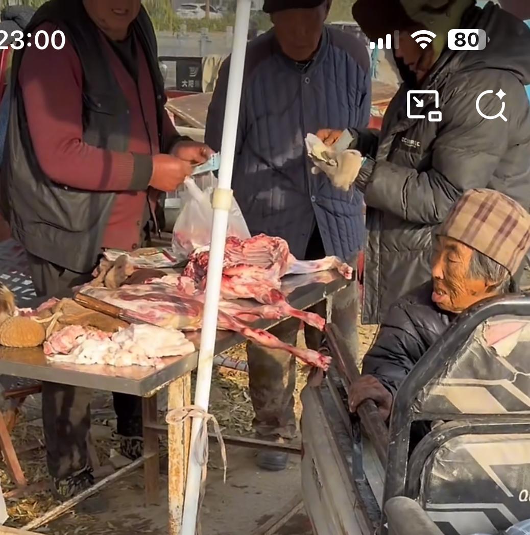 集市上无奈又暖心的一幕，老两口骑着三轮车不小心把摊主的羊肉碰地上了，摊主坚持要老