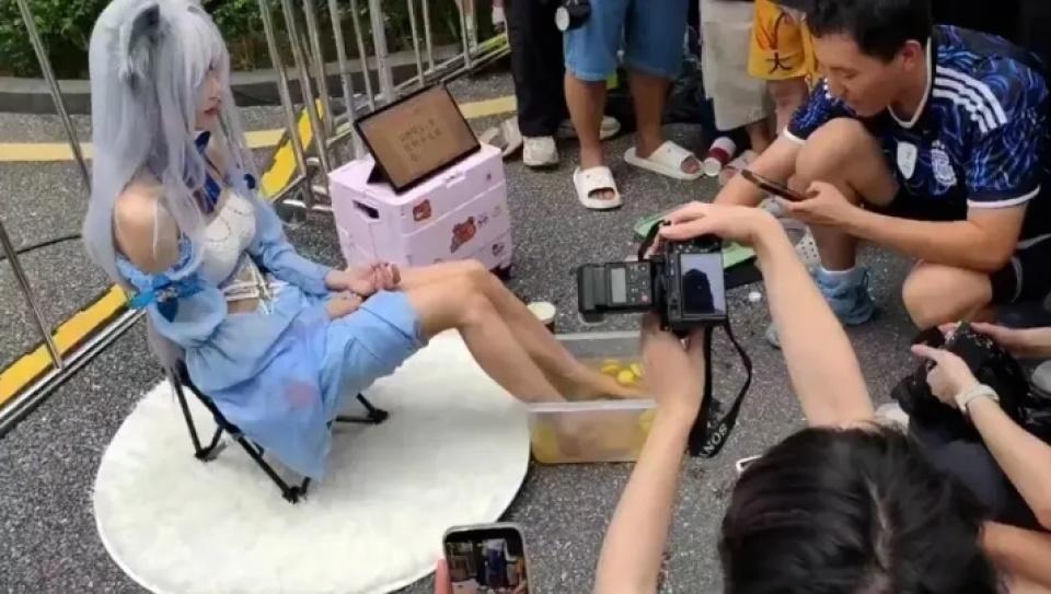 “这个世界越来越疯狂了！”广东广州，一女Coser摆摊将双脚泡进柠檬水桶，分装后