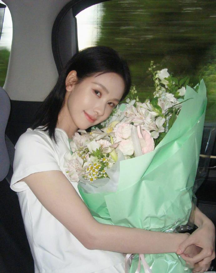陈都灵手捧鲜花，淡妆映衬温柔气质，宛如白月光女神降临。那一抹清新，恰似春日微风，