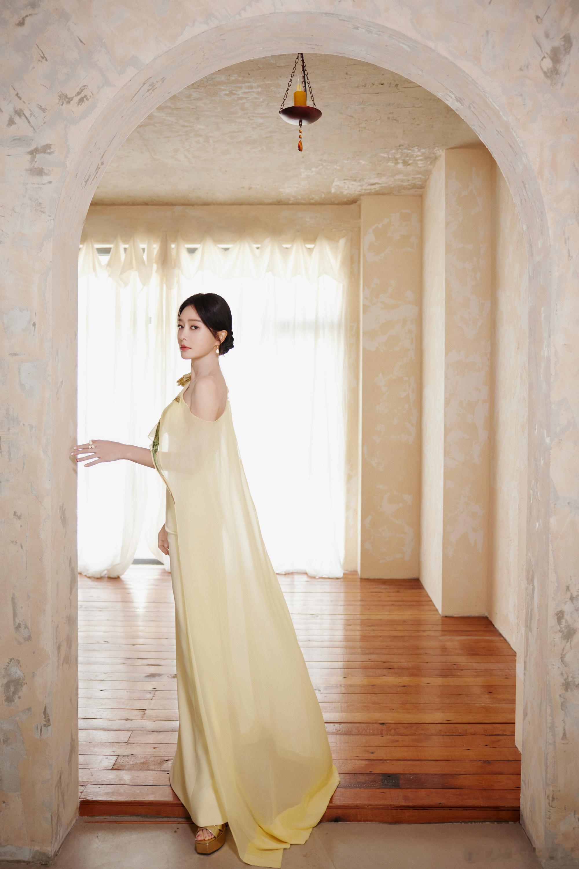 秦岚淡黄的长裙 秦岚这身鹅黄裙真的把温婉大气诠释到位了，露肩设计配金色肩花，薄纱