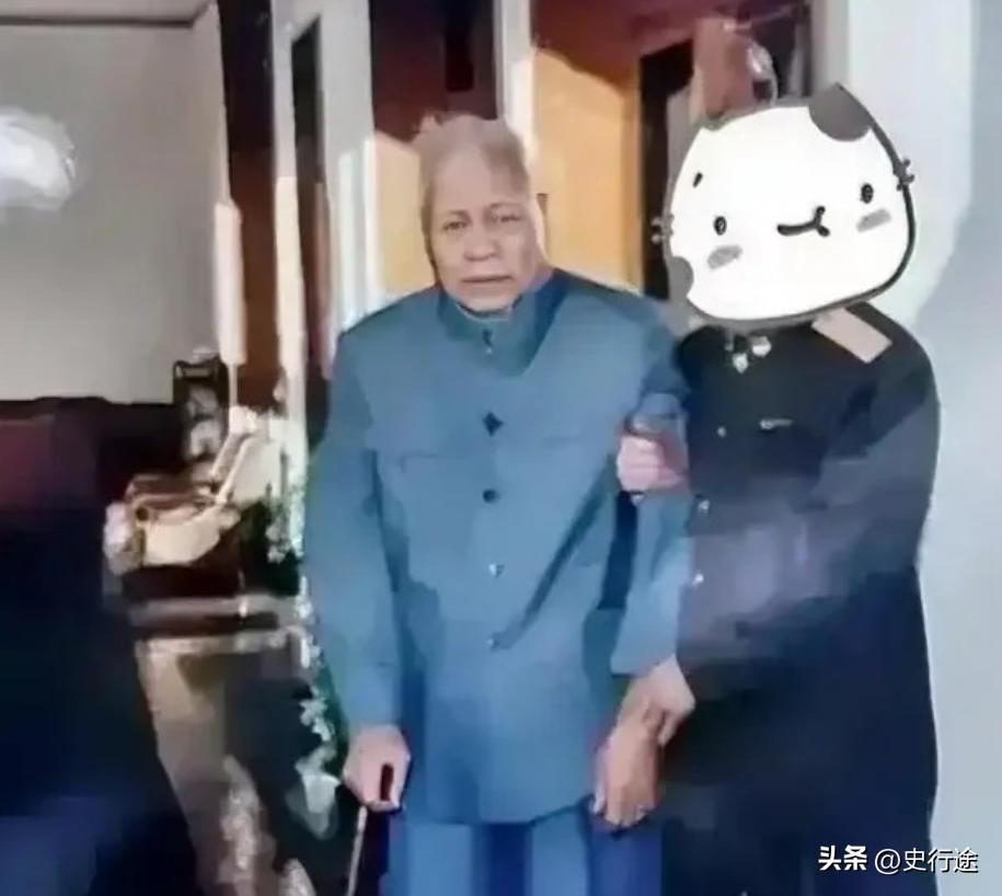 1997年，年近九旬的张宗逊将军身着蓝色中山装，手持拐杖，由工作人员搀扶着。他的