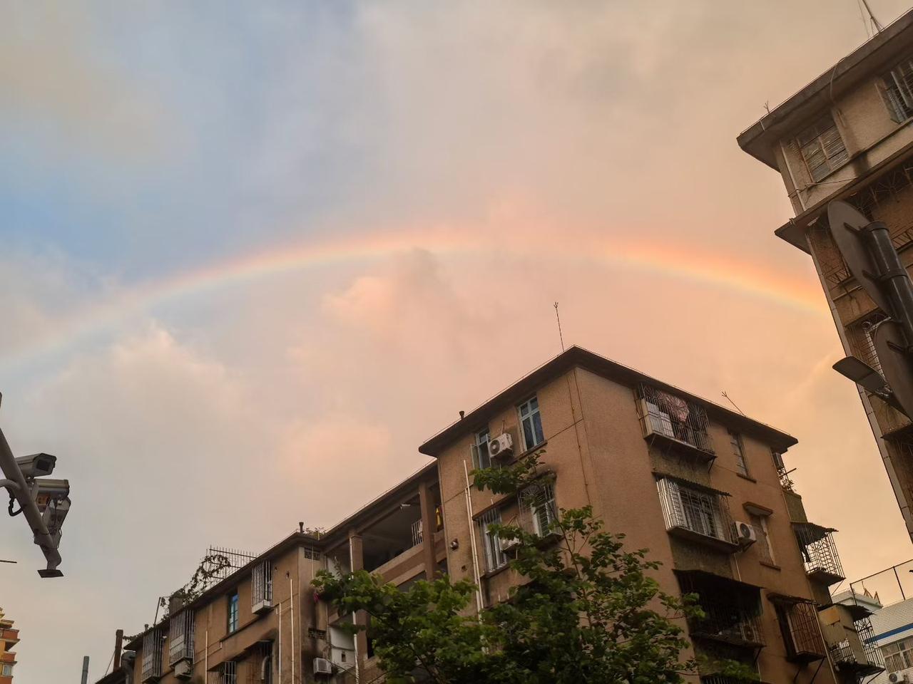 一场急雨刚歇，抬眸便邂逅一道完整的彩虹横跨城市的楼宇，刹那间，内心被治愈。

出