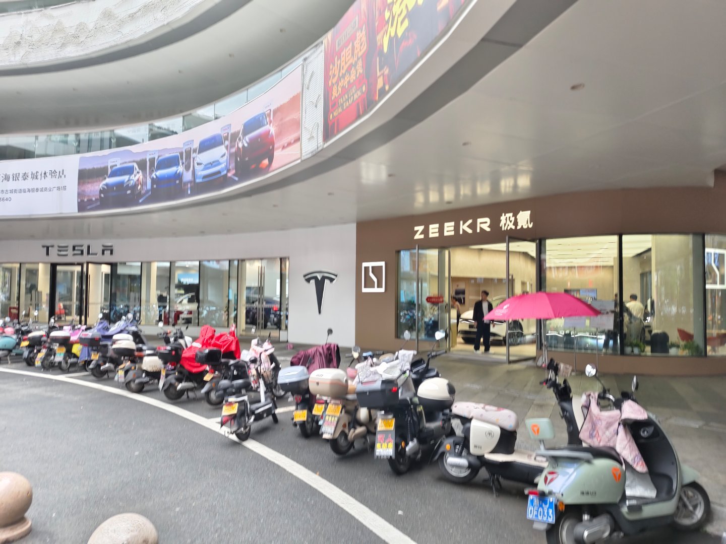 路过台州临海的极氪商超店，店里有两三组客户，而隔壁的特斯拉店里没人。这并不代表特