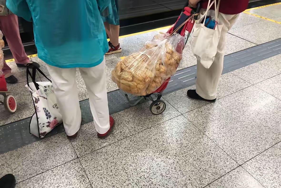 郑州地铁奇葩一幕，两位屯油条的大妈小车拉了上百根。网友问买这么多能吃了吗？大妈说