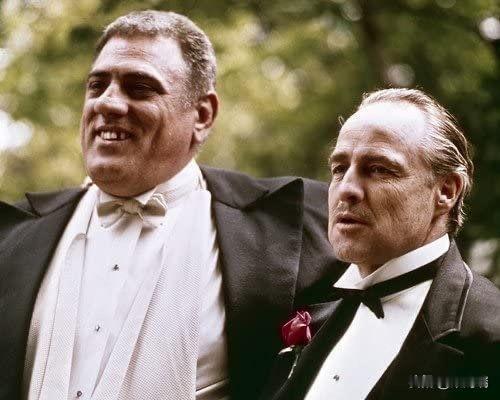 这张照片展示了经典黑帮电影《教父》（1972年）中的一幕，画面中是演员马龙·白兰