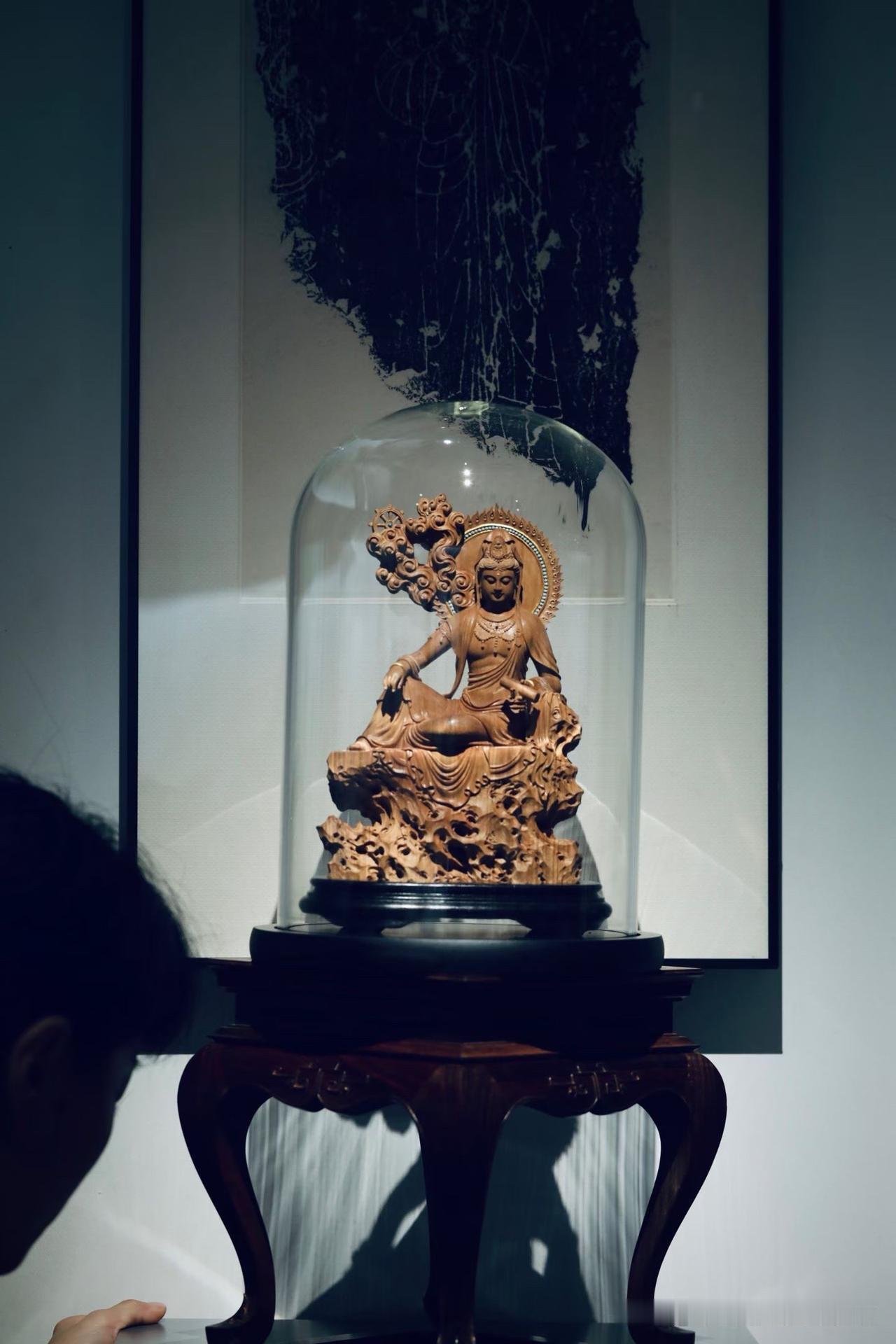 老山檀香的香气，是慢慢靠近人的。

这尊持经观音静坐山石之上，低眉含笑，神情安然