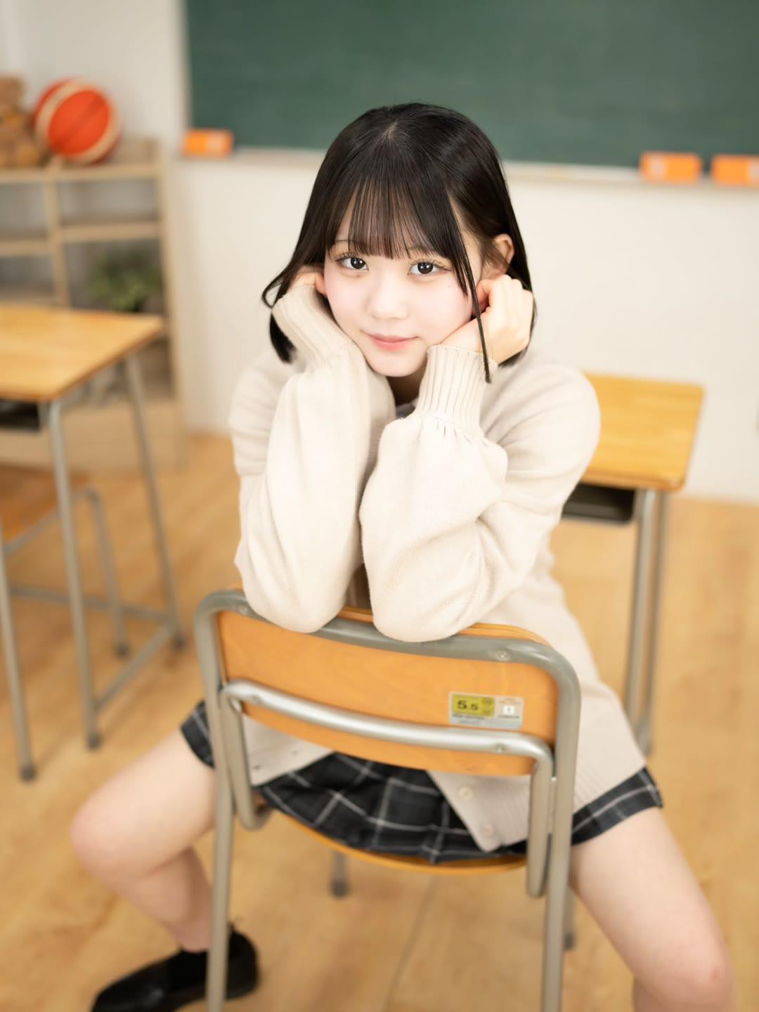 一个可爱的女孩坐在教室里。