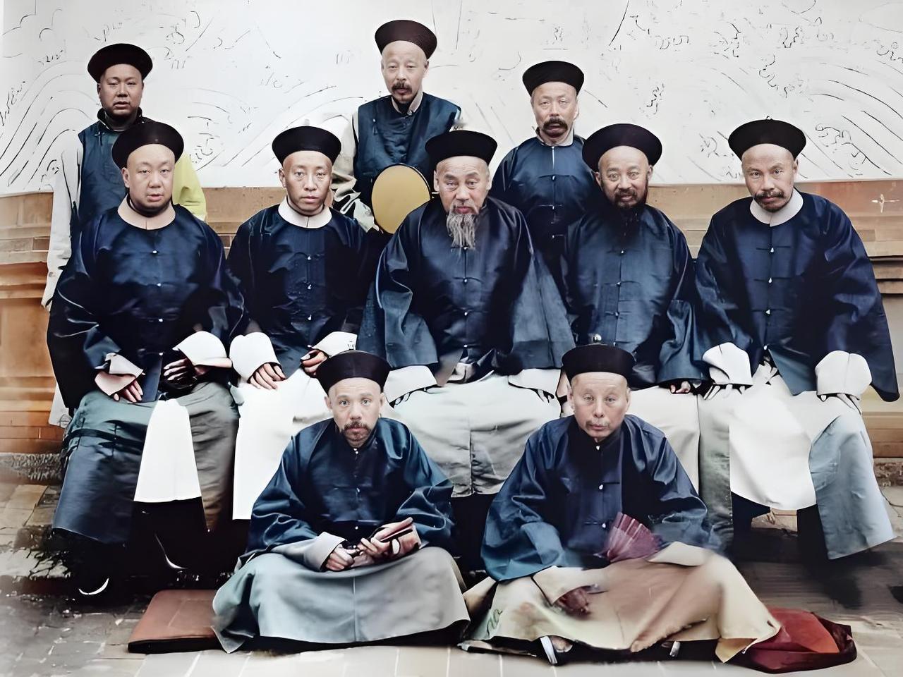 这张照片，定格了晚清一群官员的合影。
画面中，官员们身着传统长袍马褂，头戴瓜皮小