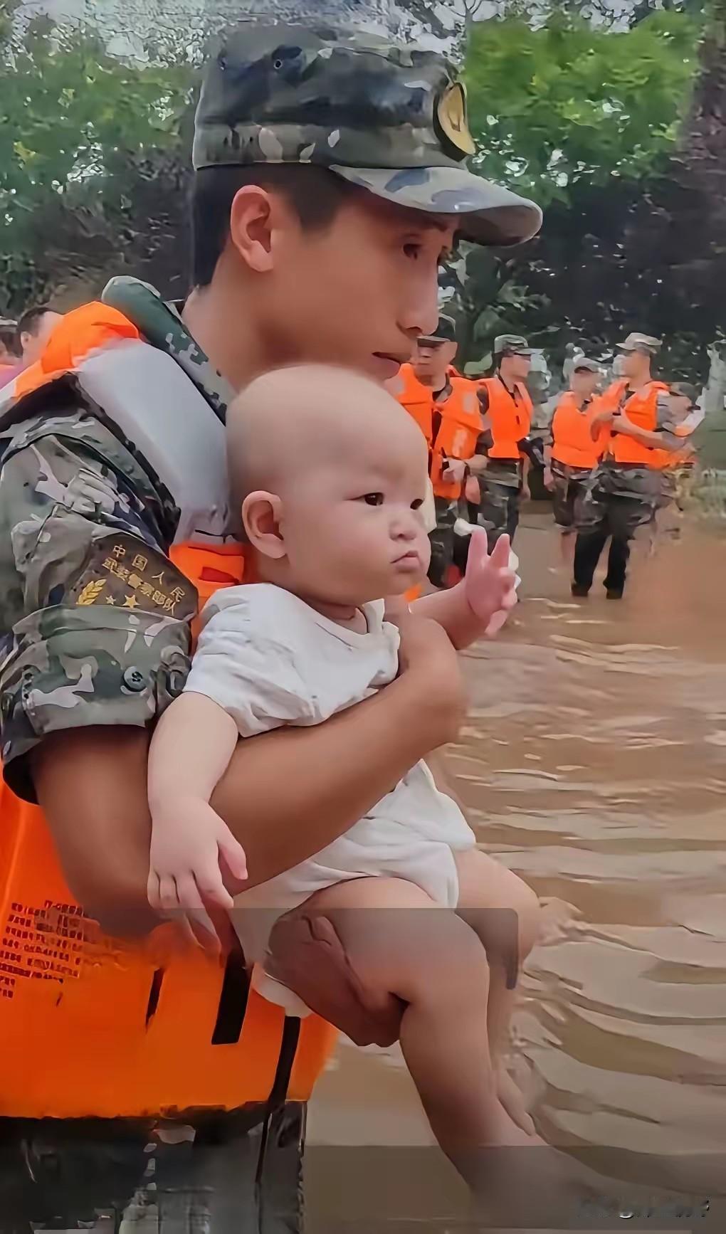 洪水中抱着孩子的武警战士也还是个孩子，那张稚气未脱的脸告诉我们，他也是父母身边没