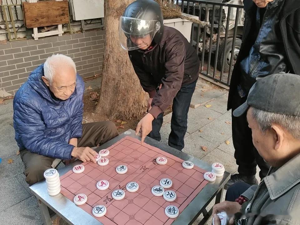 民心河畔的棋摊，最近热闹得恰到好处。
之前这里天天围满下棋的老街坊，棋子往硬木桌