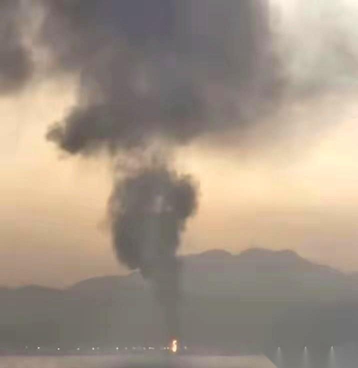 阿联酋富查伊拉港口，黑烟遮蔽了天空。据报道，就在拦截警报划破长空的瞬间，12枚弹
