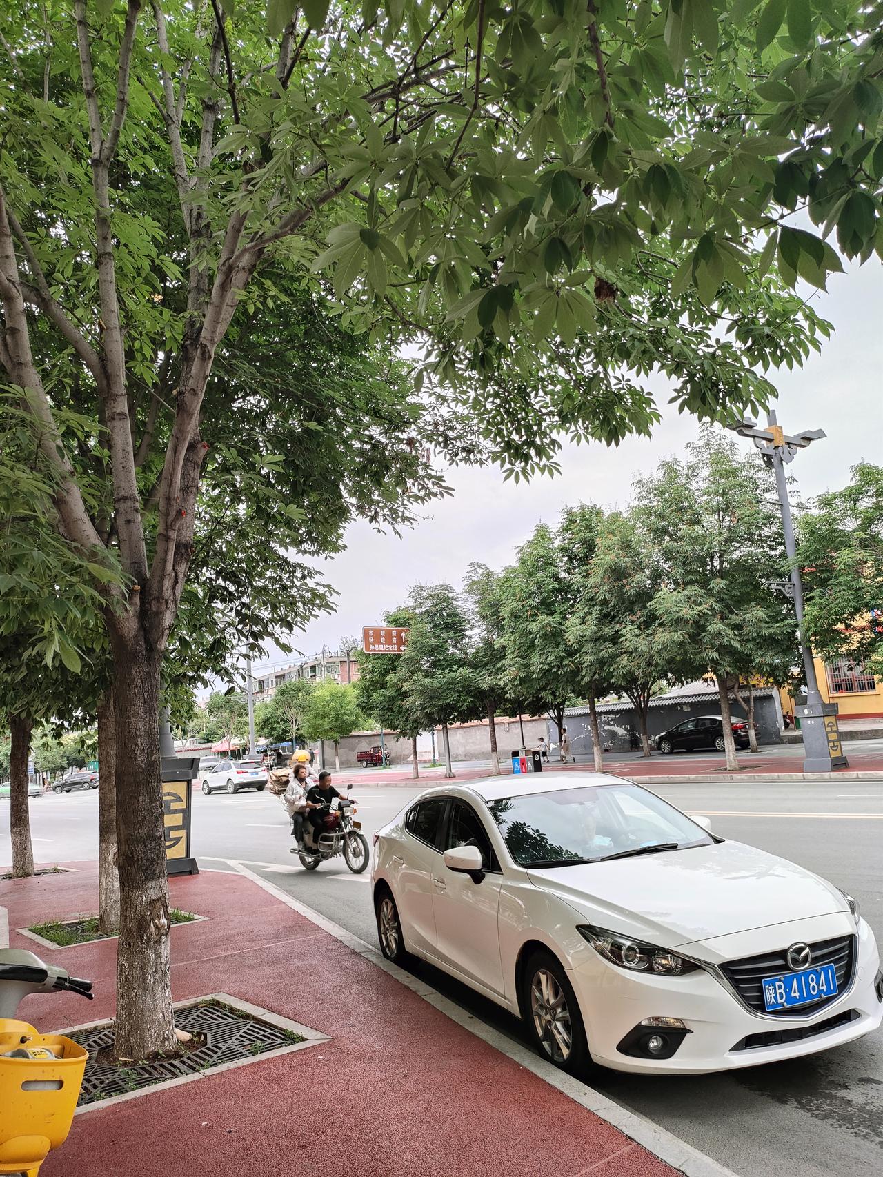 晒图笔记大赛沿街绿树撑开层层浓荫，红黄墙面的小店安静立在路边，车辆、摩托缓缓穿行