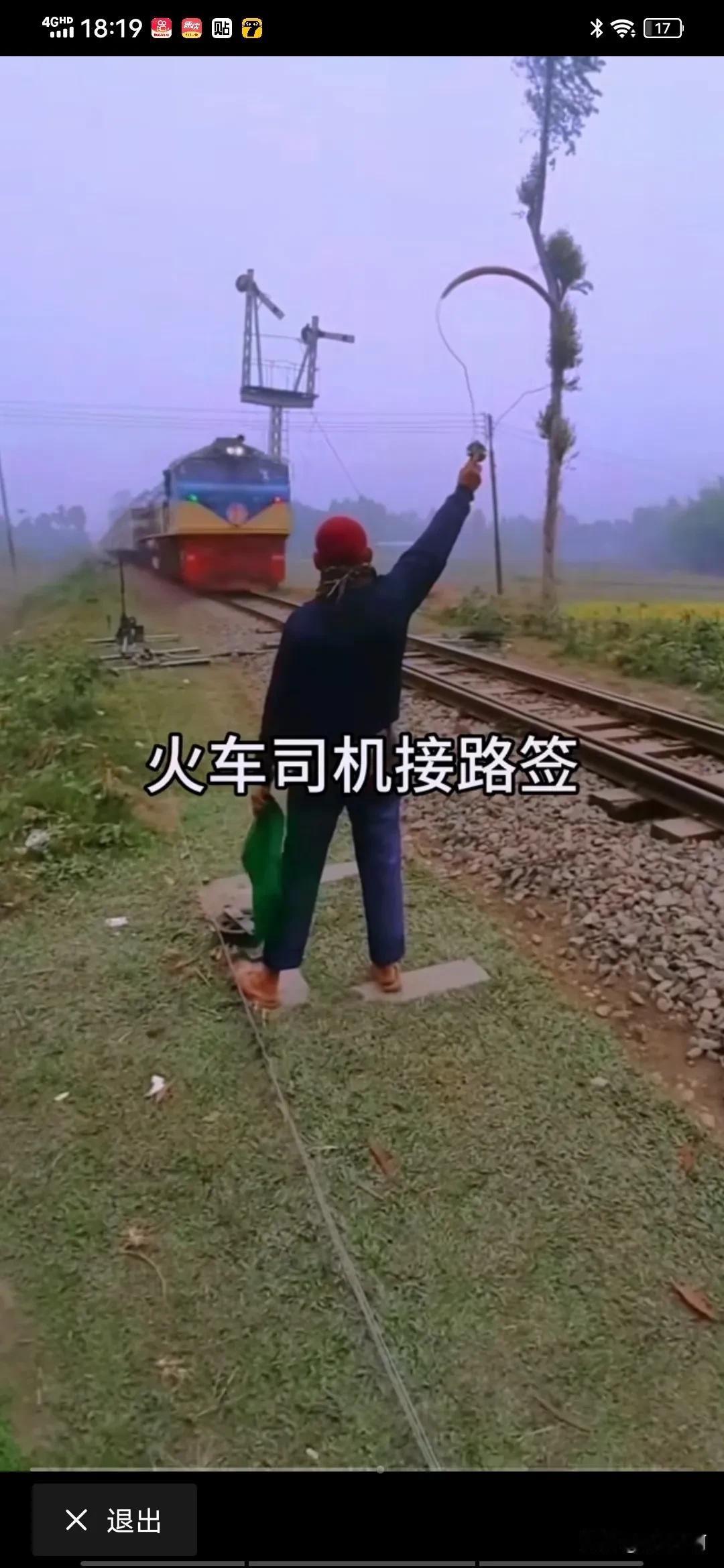 这是列车通过本站驶入下一站的凭证，副司机半蹲在车门处，一手抓紧车门扶手，面对持路
