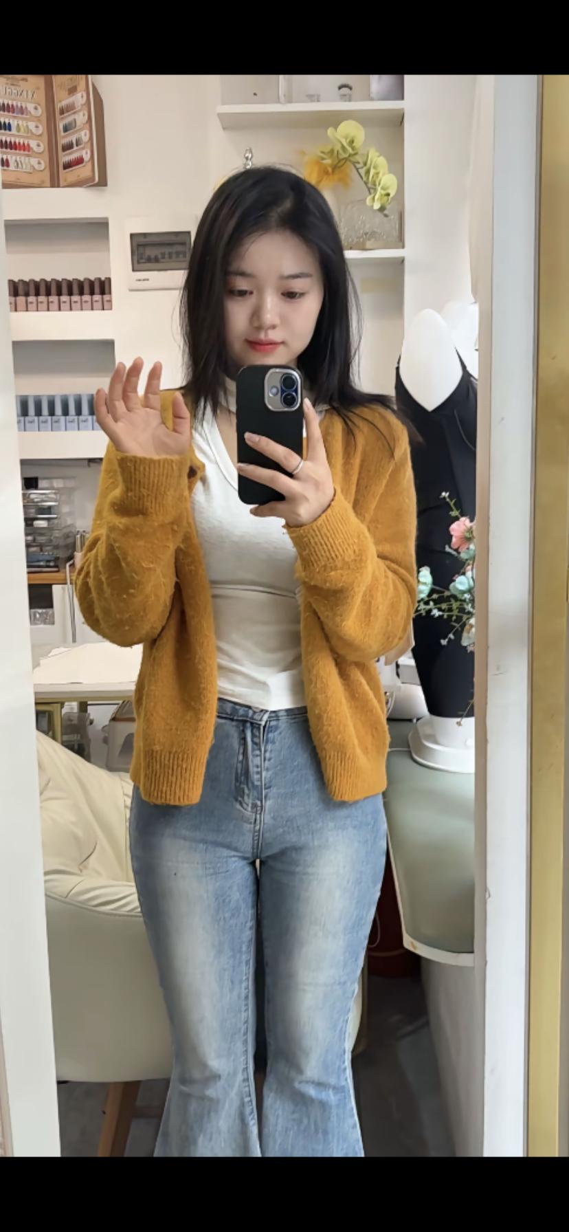 穿橙色毛衣，拍个镜子自拍。