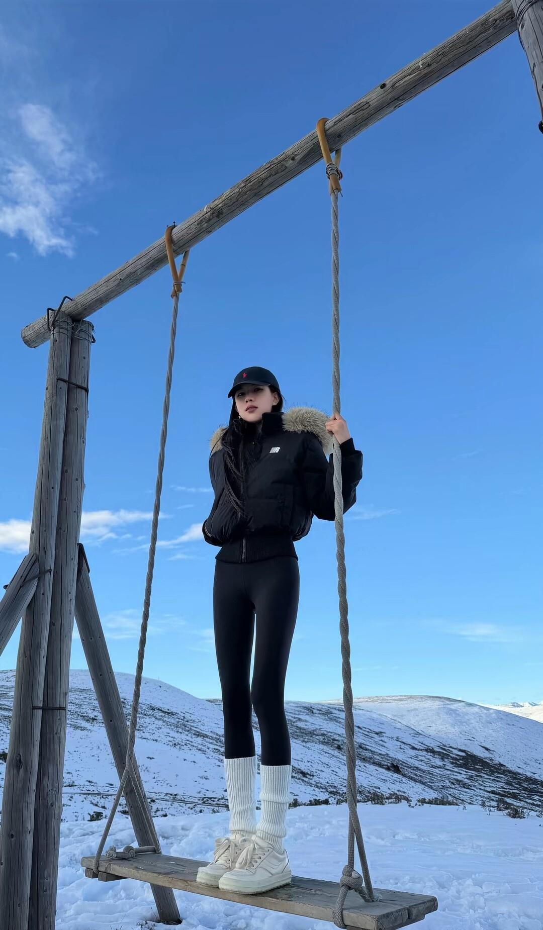 冬日雪景中的少女，站在木制秋千上，享受宁静的时光。