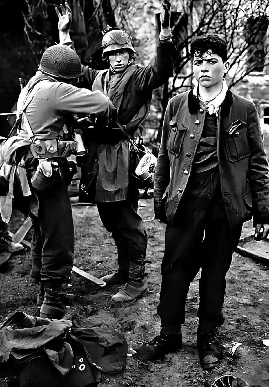 1945年，美军攻占德国科布伦茨市， 两名德军狙击手在弹尽粮绝下被俘，一个高举双