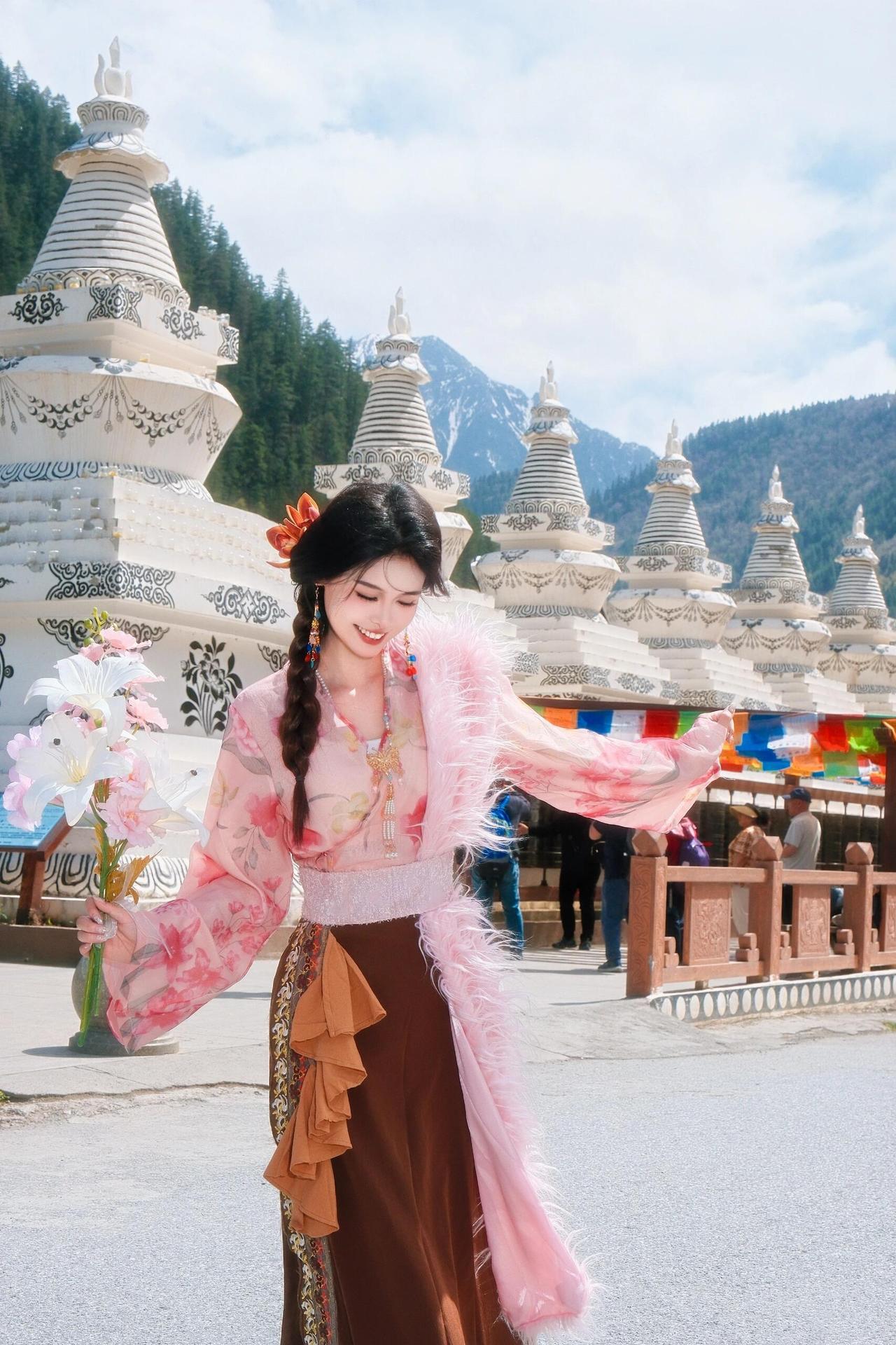 她穿着传统服饰在风景优美的地方拍照