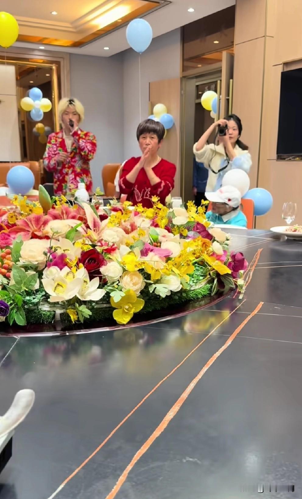 孙子成成两周岁生日，甘宇翼的妈妈穿着大红色的毛衣，拍着手，高兴之情溢于言表。身旁