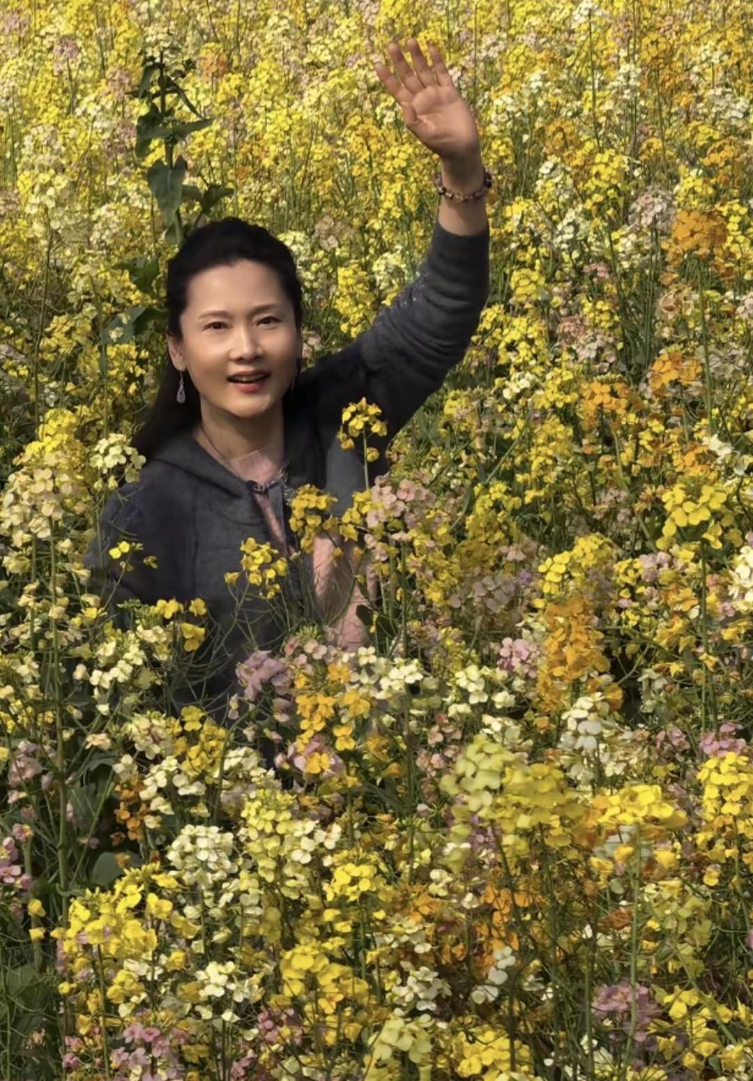 何赛飞的这张照片照的不好。可能是光线的缘故吧！油菜花不够黄，她的衣服颜色太暗，肤