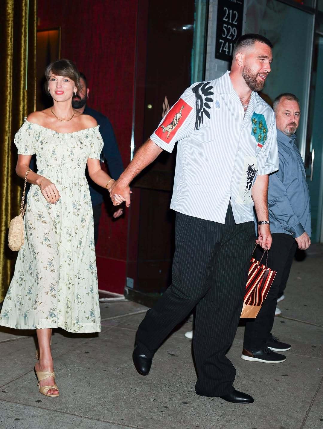 霉霉与未婚夫纽约牵手街拍，霉霉身穿一件淡黄色露肩碎花连衣裙，整体造型温柔又清新，