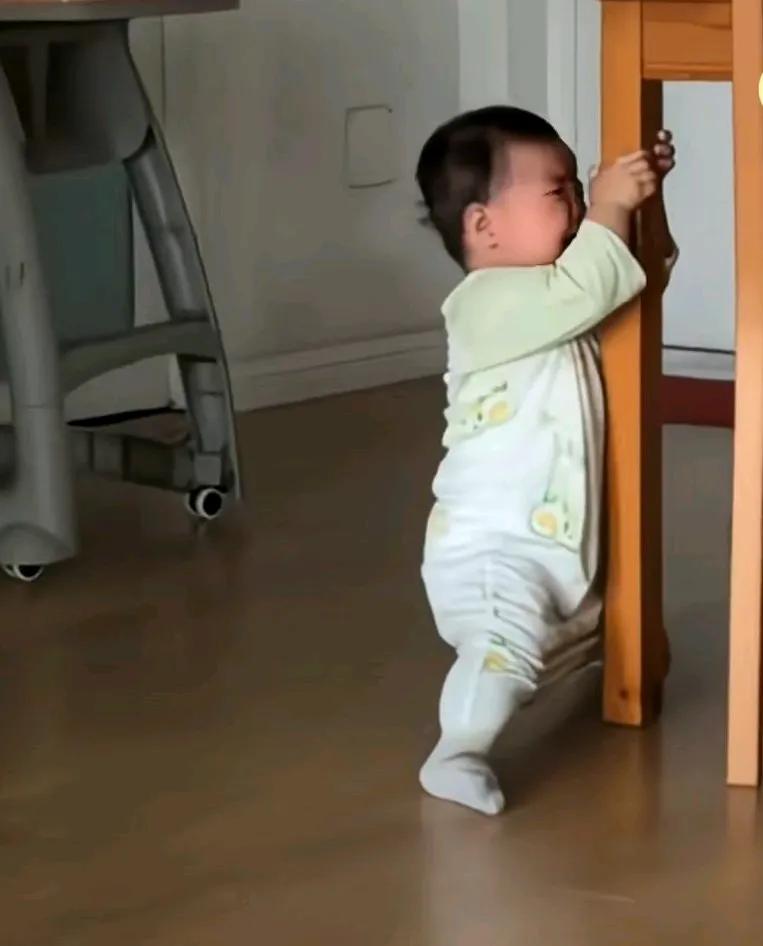 学走路的宝宝穿的袜子太滑，拉着桌子，急得直摇头，
怪就怪说也说不清，
说不出来啥