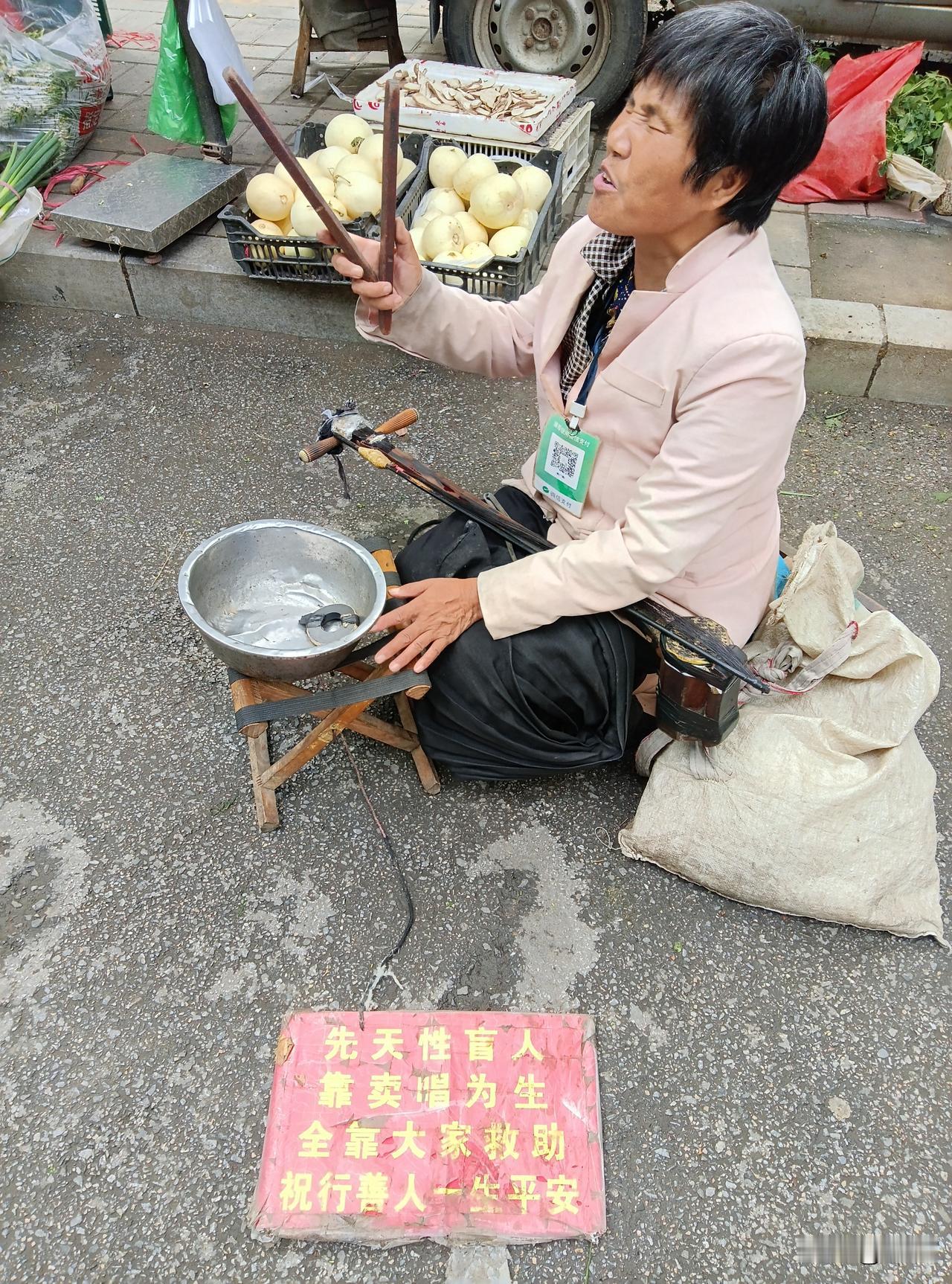 弱者太容易满足了
 刚刚在菜市街散步，偶遇一位盲人大姐在街头又拉又唱。
曲调并不