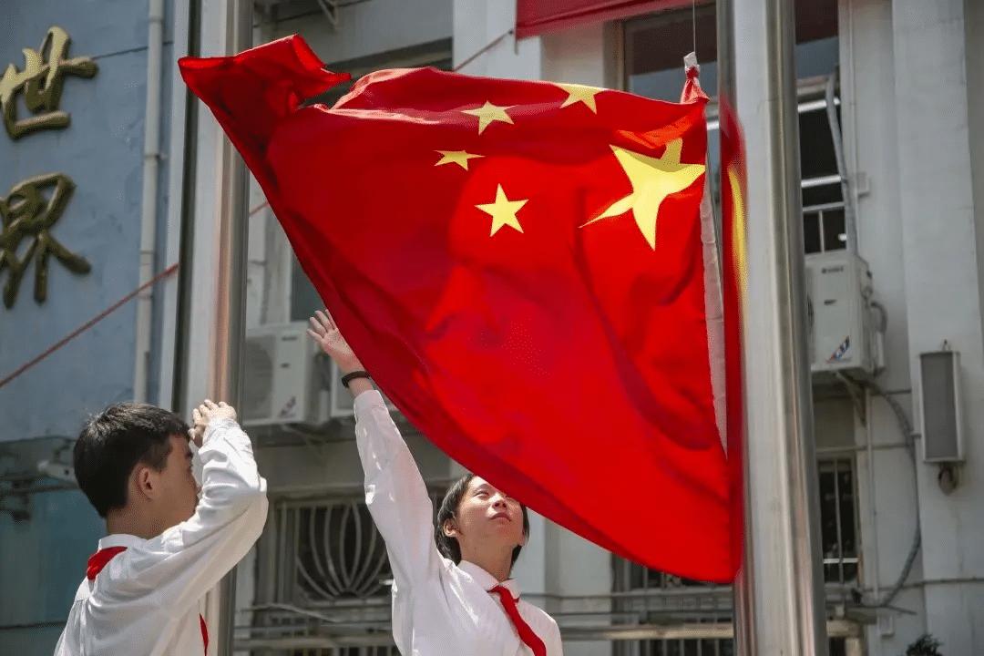 一边是气派亮丽的豪华校园，一边却是污损褪色、甚至边缘已经破掉的国旗。这不是什么荒