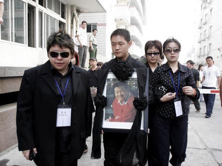 2005年，傅彪遗体告别仪式现场，画面中间手捧遗像的是傅彪之子傅子恩，左侧同行者