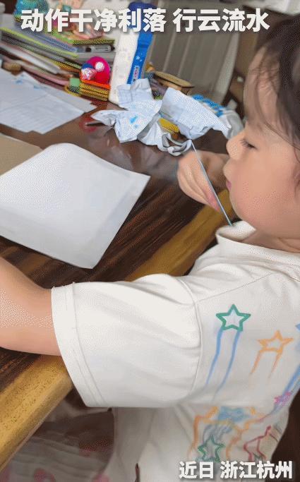 “上人民日报了！”浙江杭州，小学一年级女孩自己包书皮。没想到，她的动作干净利落，