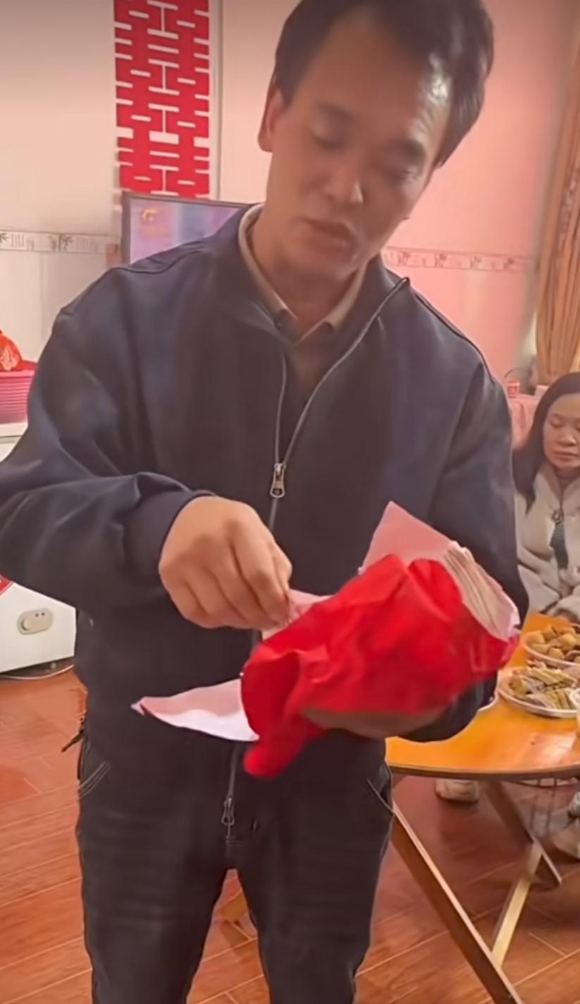 接过彩礼，从里面象征性抽出两张，随手将彩礼返还，同时从另一个兜里又掏出两沓钱，放
