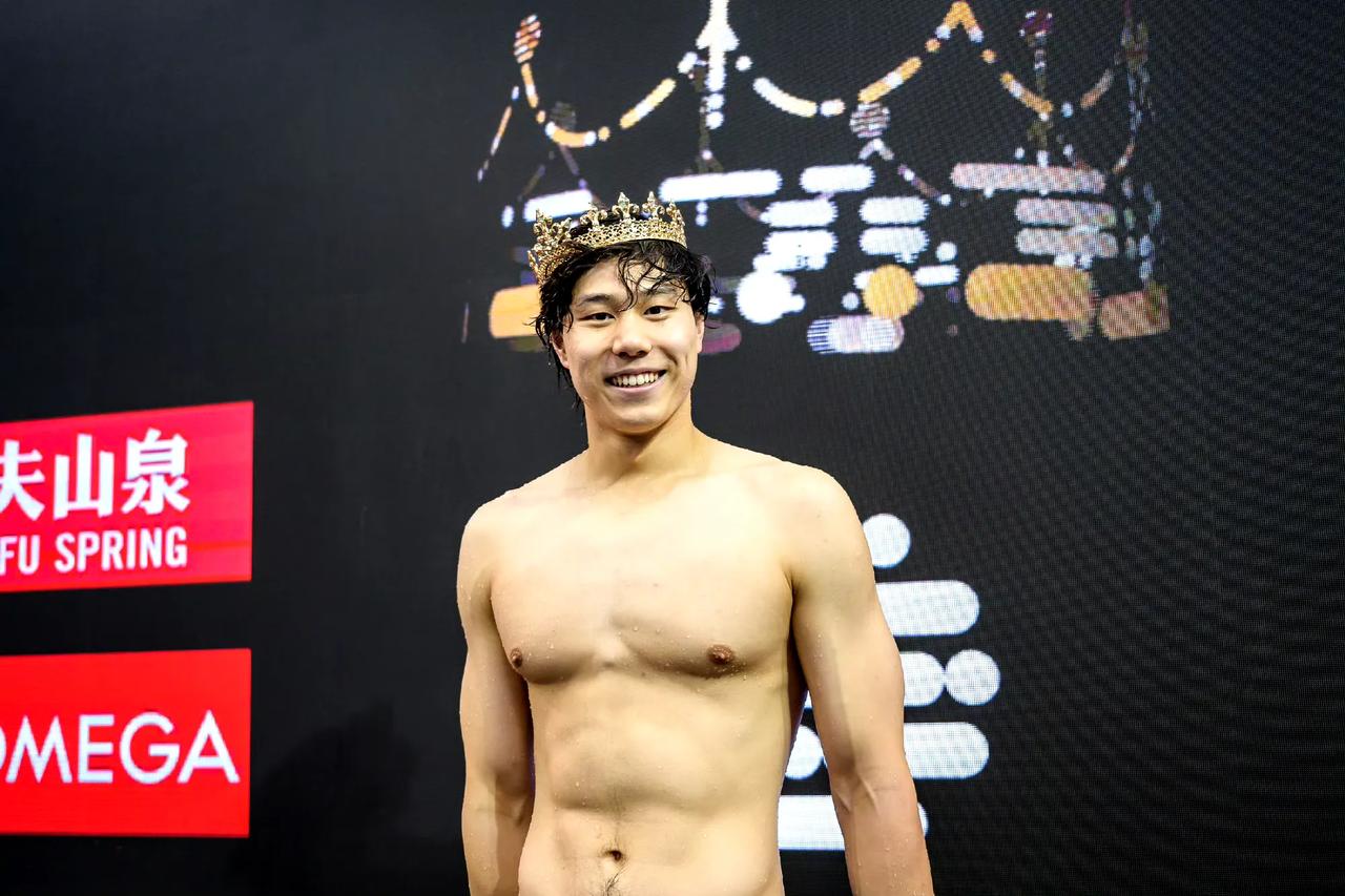参加游泳世界杯新加坡站比赛后的覃海洋，这张照片是他获得五十米蛙泳冠军后头带王冠的