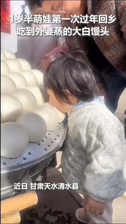 萌娃贴脸啃咬外婆蒸的大白馒头一家人团团圆圆开开心心，这才是过年应有的样子。在甘肃
