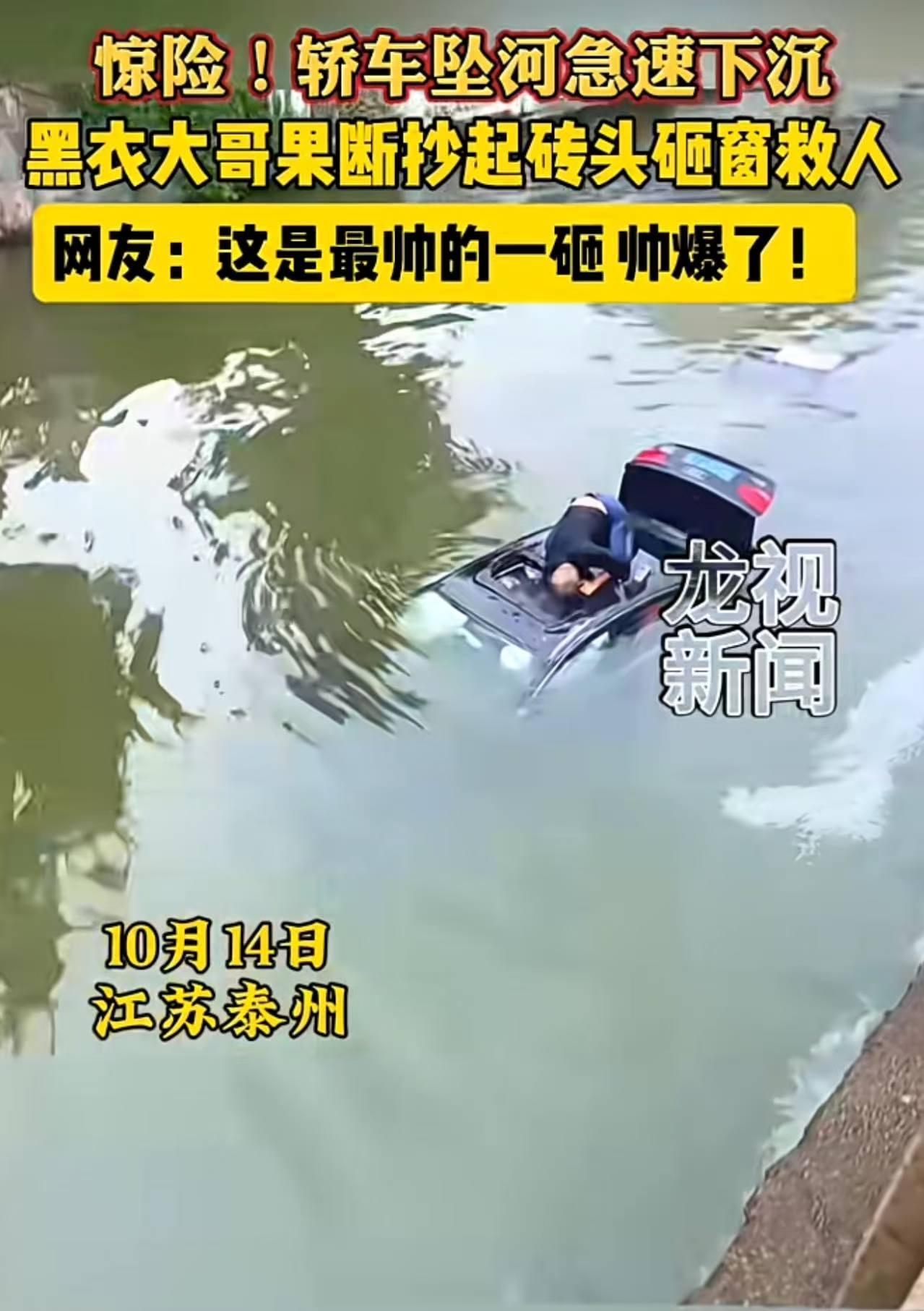 江苏泰州，一轿车冲出马路坠河极速下沉，一黑衣男子抄起砖头果断下河，爬上车顶砸窗救