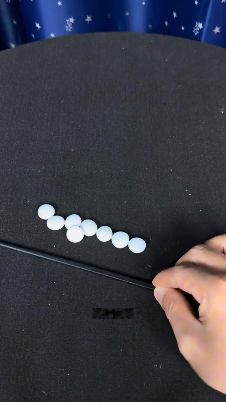 桌子上有9颗棋子对不对？瞅好了，这不是魔法，只是一个普通的魔术。用一根筷子给它拨