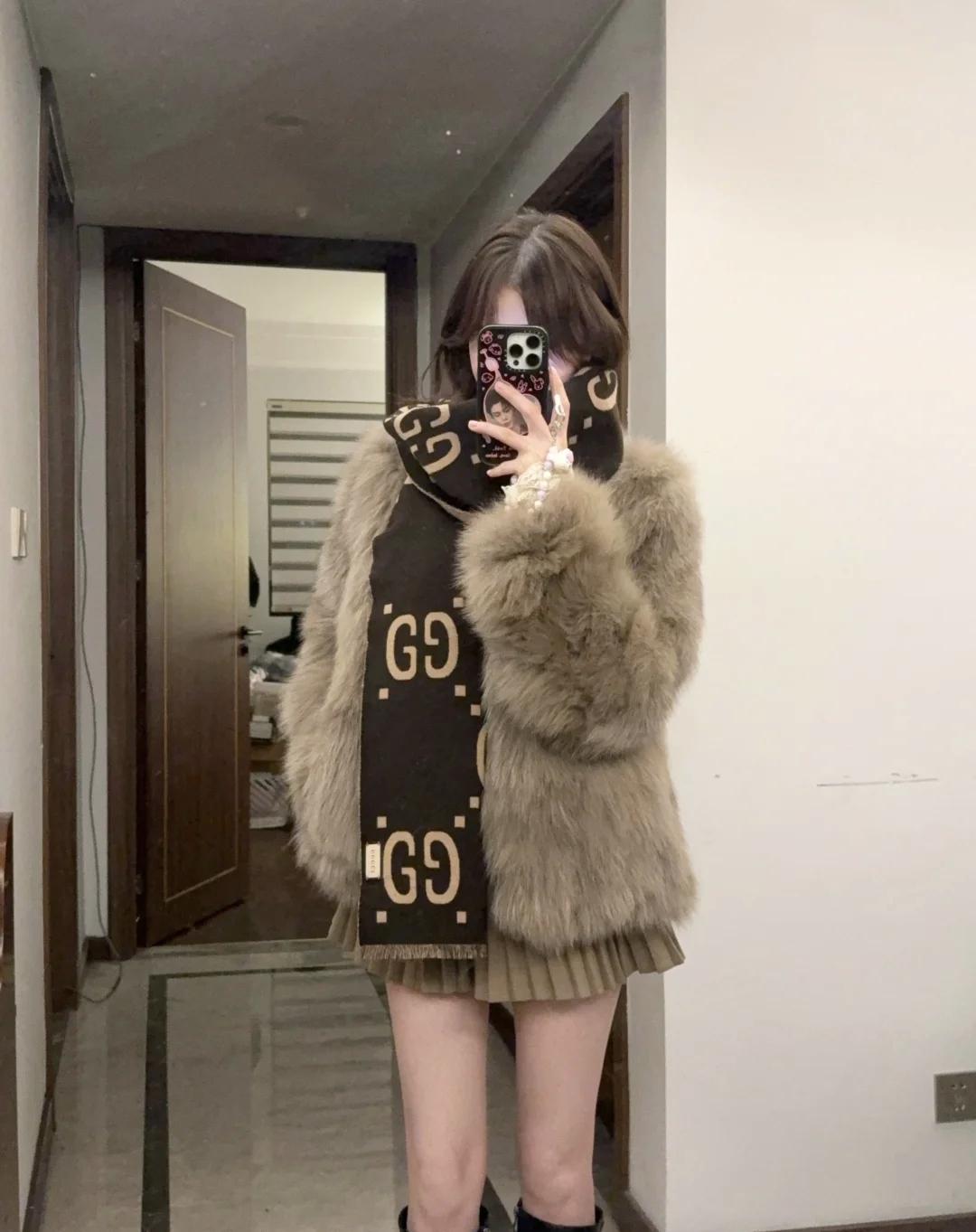 毛绒外套裹住了所有怕冷的小情绪，百褶裙又偷偷藏着少女心，焦糖色包包和老花围巾是氛