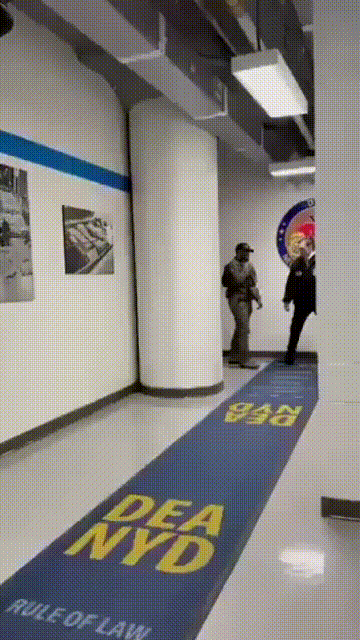 马杜罗神态自若地走在纽约禁毒局，被两名联邦特工带着，他身穿黑色连帽运动衫，和旁人