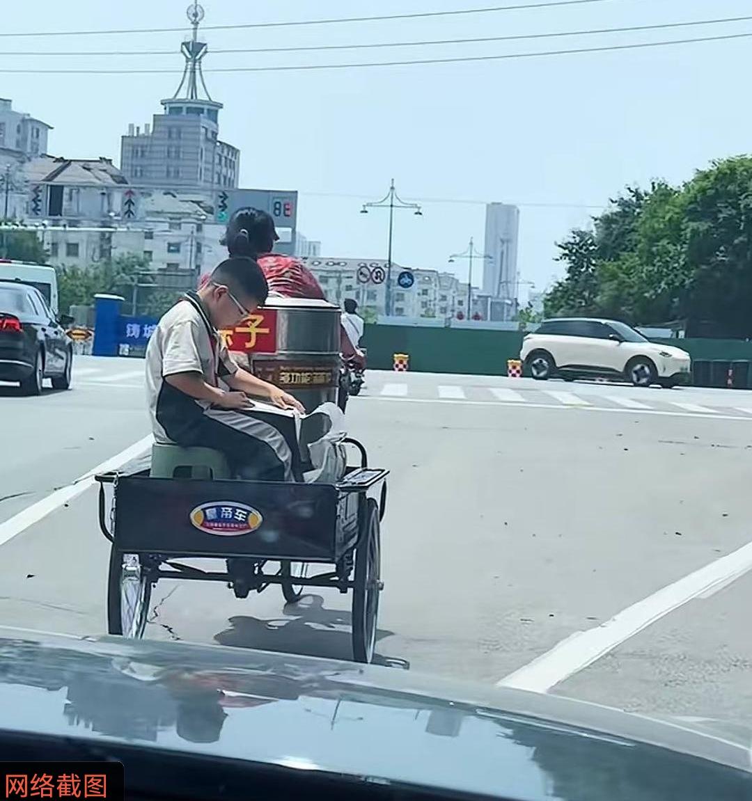 山东聊城有名女子，这天独自蹬着三轮卖粽子，可三轮车的车后，还有小男孩坐在小凳子上
