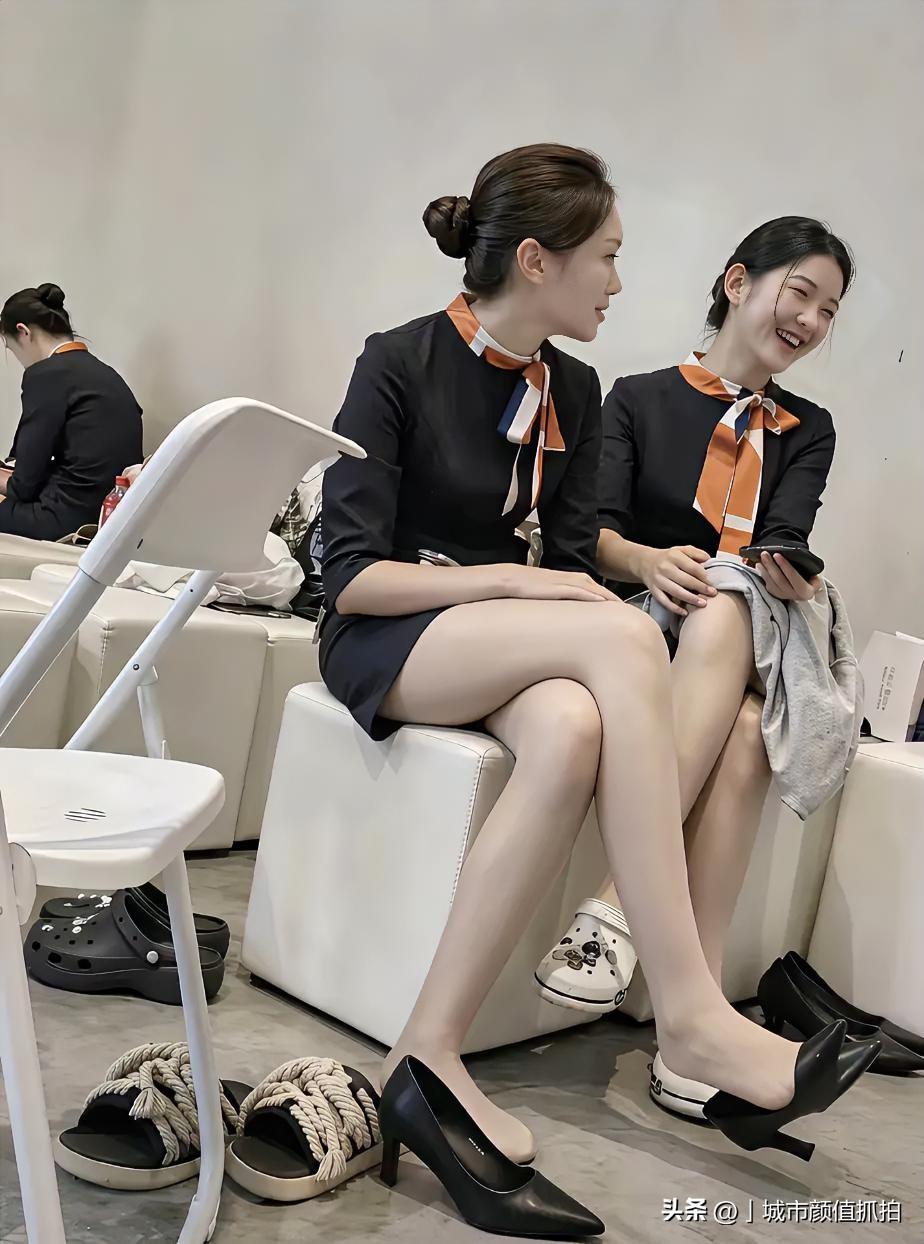 航司制服盘发一丝不苟，脚边却摊着洞洞鞋、麻绳凉拖一堆"飞行续命神器"，俩人凑头笑