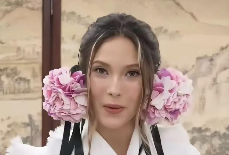 谷爱凌的妆造俏皮灵动。
两朵丰美的鲜花彰显着生命力，倾泻悬垂堆叠出的的白木耳造型