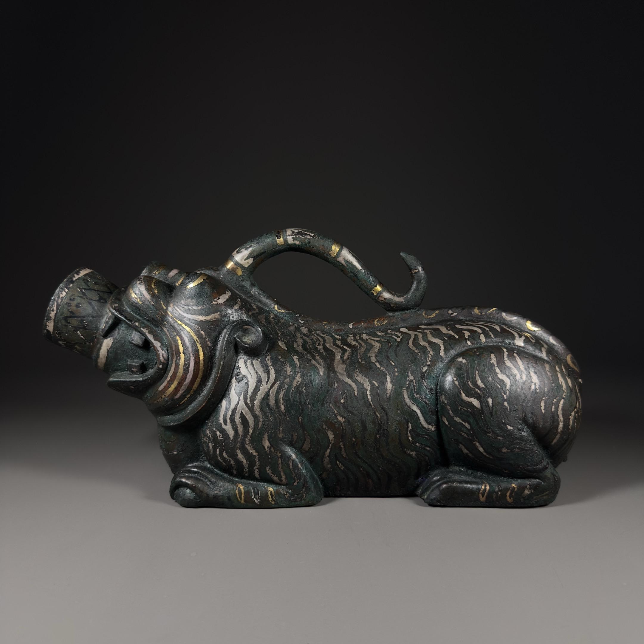 青铜错金银夜壶。错金银工艺是将金银丝、片嵌入青铜器表面预先刻好的槽纹中...