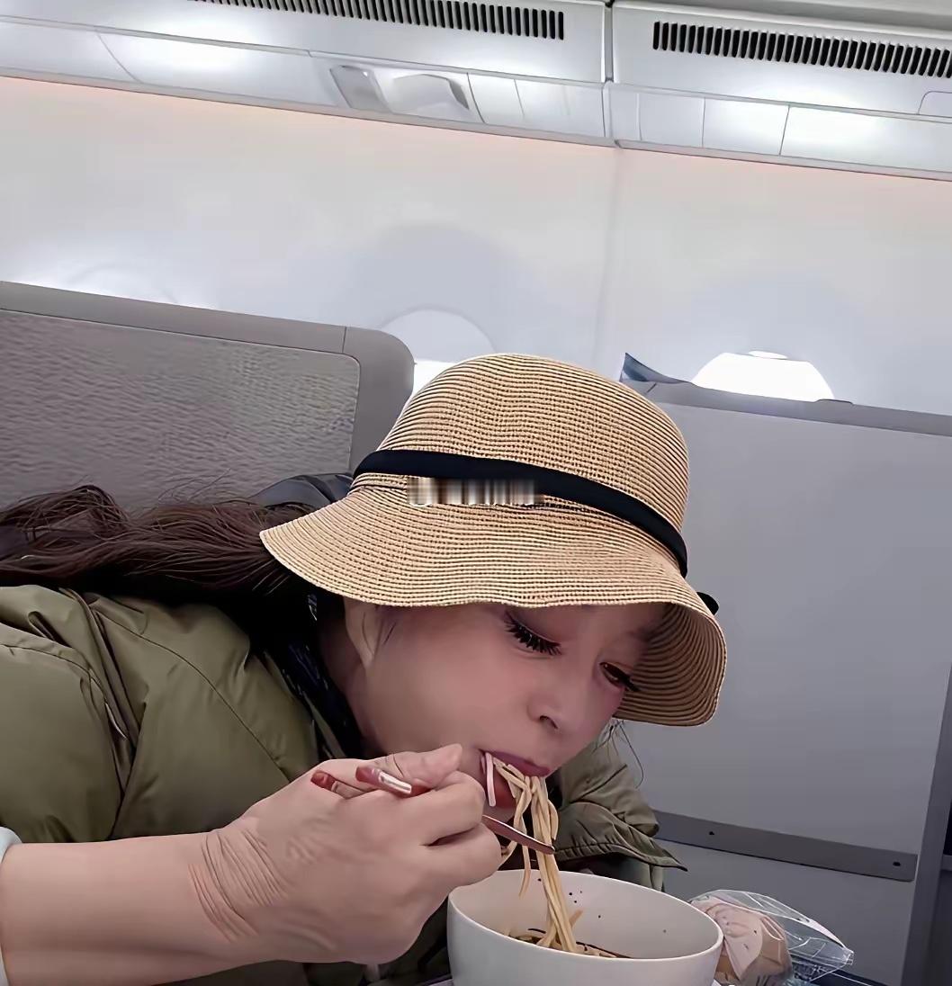 刘晓庆在飞机上吃面条时的一幕，看样子饭量不小。 
